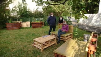 Kurt Pregitzer (li) mit einer Projektteilnehmerin und Ernährungsberaterin Verena Klopf (re) genießen die selbst gebaute Sitzgruppe