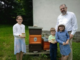 Familie Jänsch präsentiert den verarbeiteten und abgefüllten Honig am Bienenkasten der Arnsteiner Christuskirche