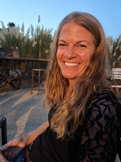 Lisa Heußner sitzt lächelnd in der Abendsonne